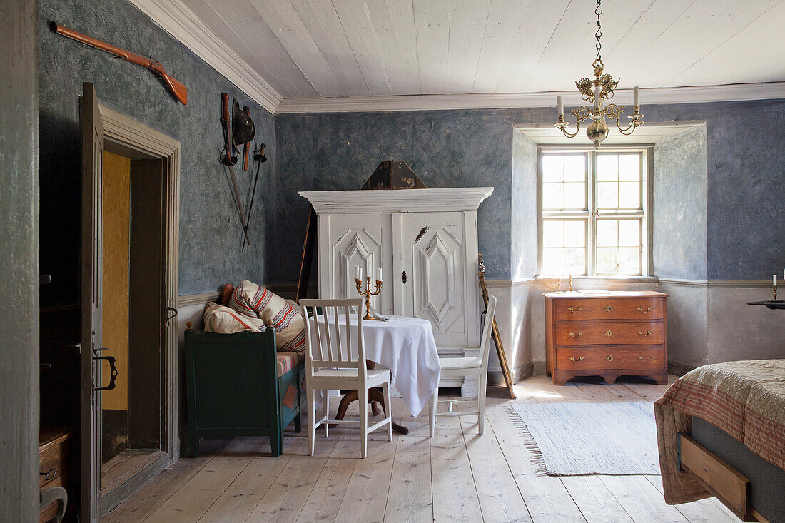 Rustic bedroom with antique white wardrobe and wooden floorboards