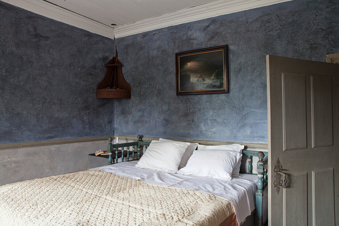 Rustic bedroom with blue walls and antique bed frame