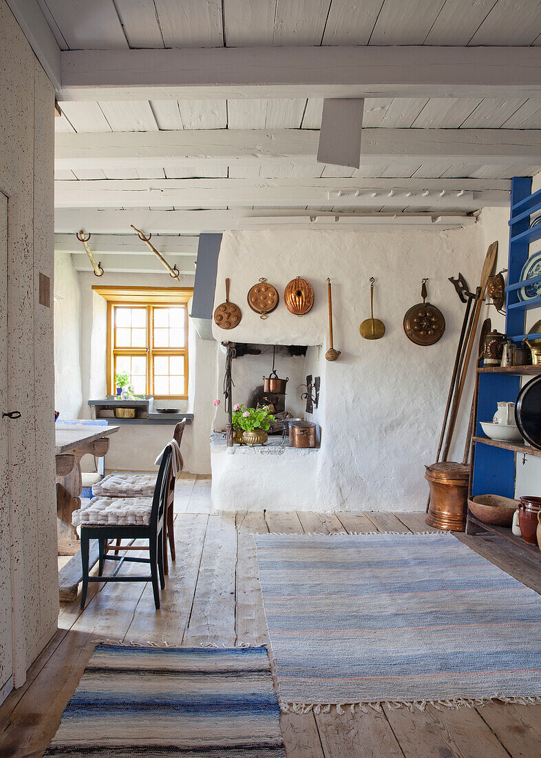 Ländliche Küche mit rustikalen Kupferpfannen und Holzfußboden