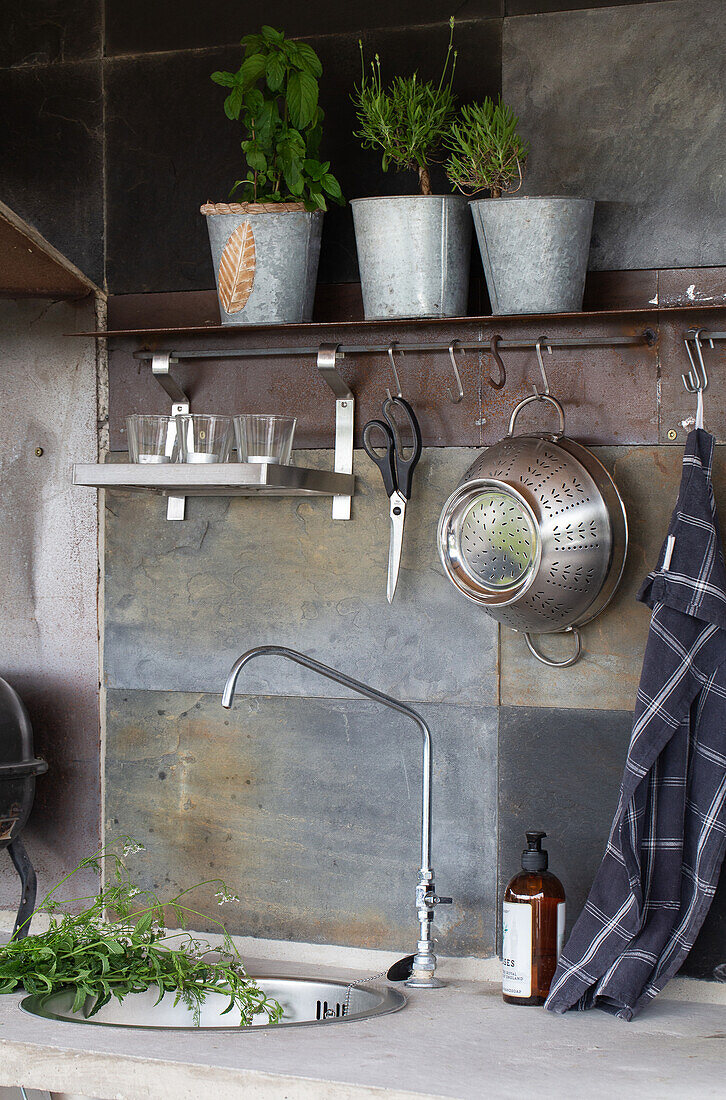 Modern outdoor kitchen with herbs and grey tiles