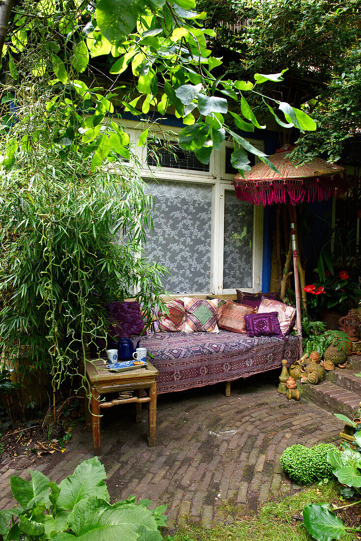 Oriental seating area with cushions in the lush garden