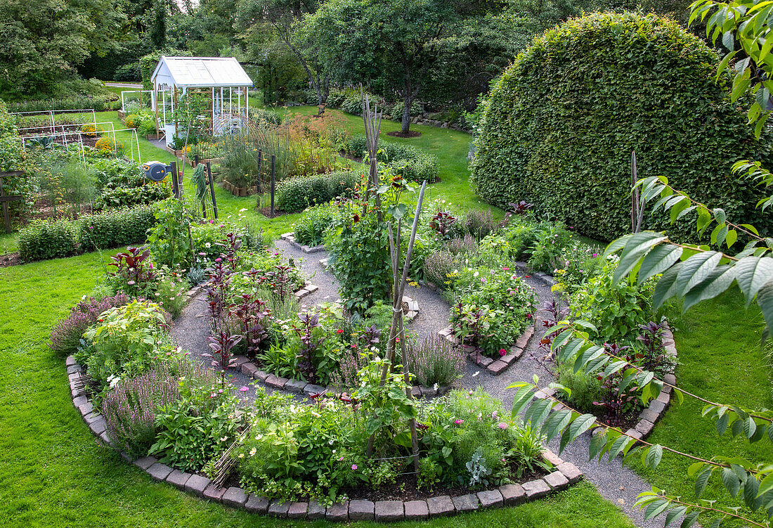 Rundbeet mit Kräutern und Gemüse im großzügigen Garten