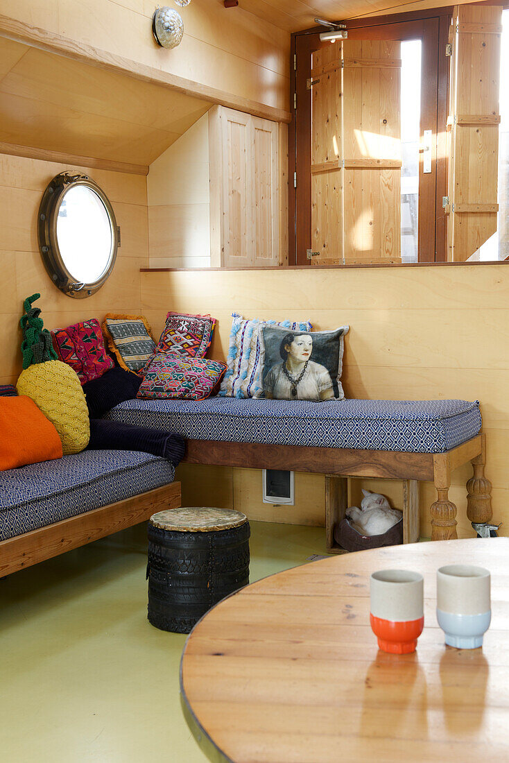 Corner benches with colourful cushions in a wood-panelled room