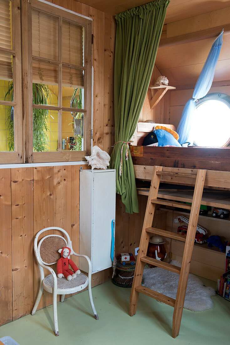 Children's room with half-height wooden loft bed and ladder