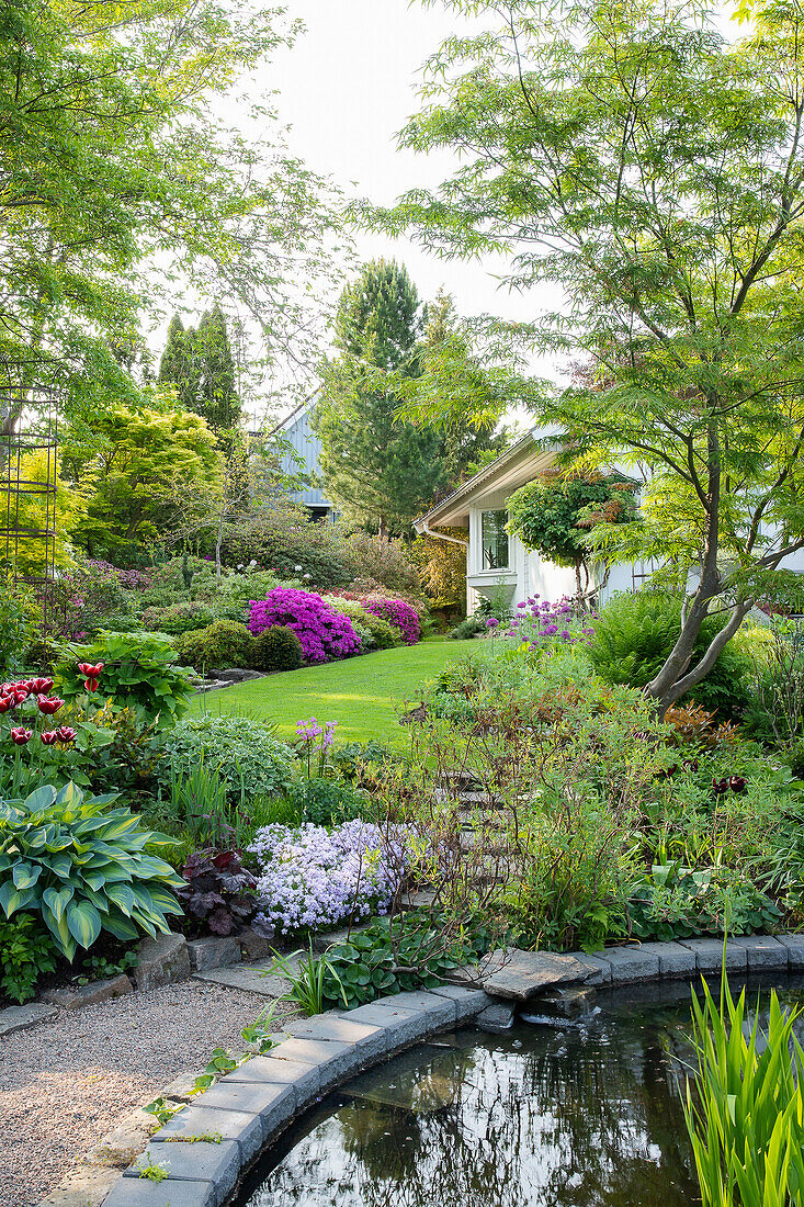 Lush garden with pond in spring