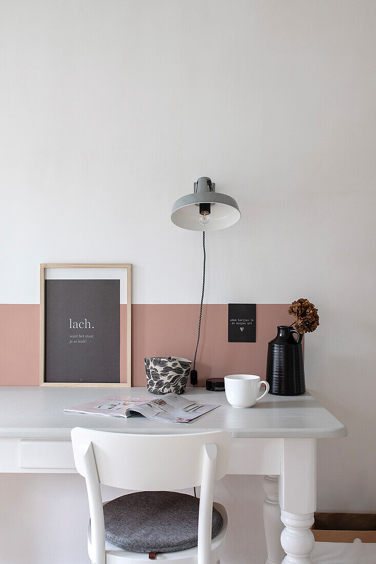 White desk with wall lamp and decoration in muted colours