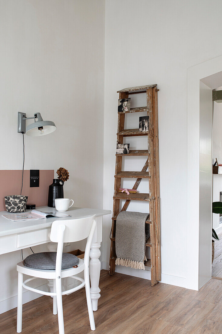 Corner desk with lamp and wooden ladder as storage element