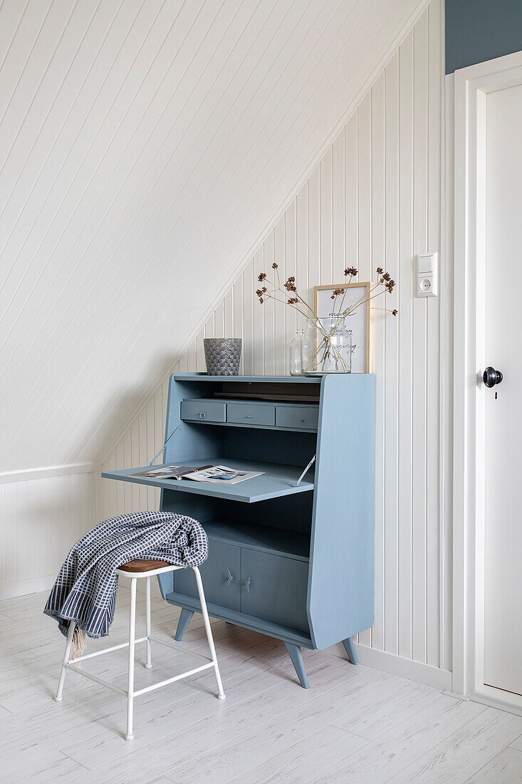 Light blue secretary in Scandinavian design under a sloping roof