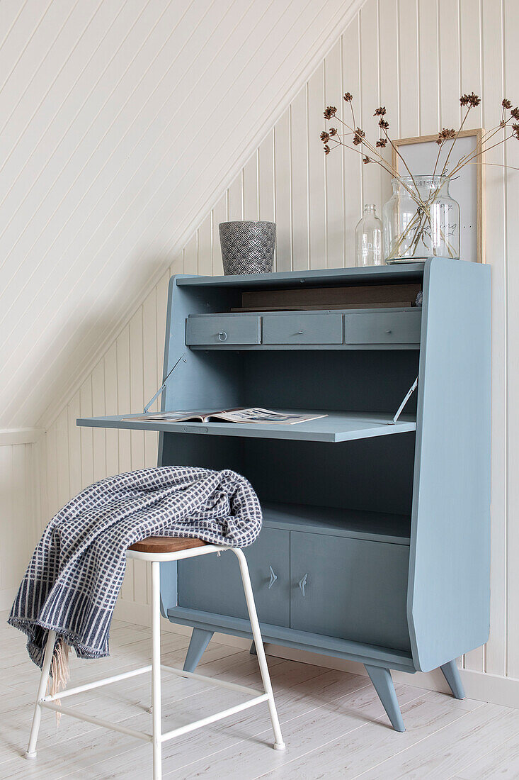 Light blue vintage secretary in Scandinavian design under sloping roof