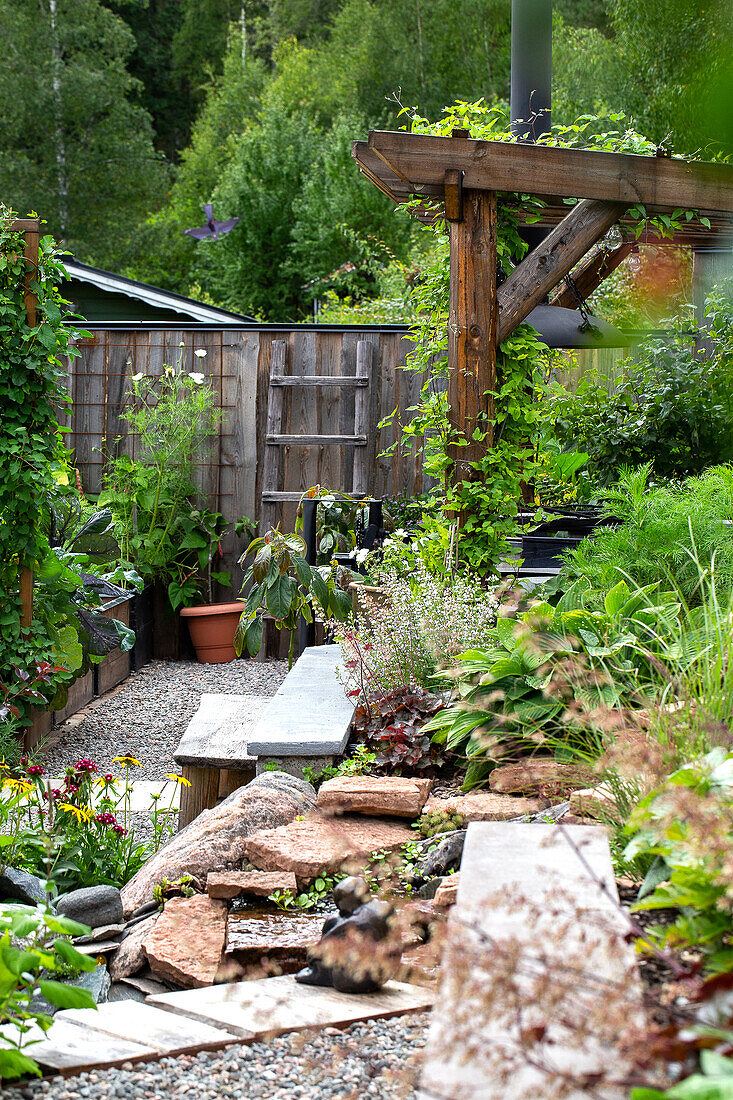 Green garden with wooden pergola and gravel path