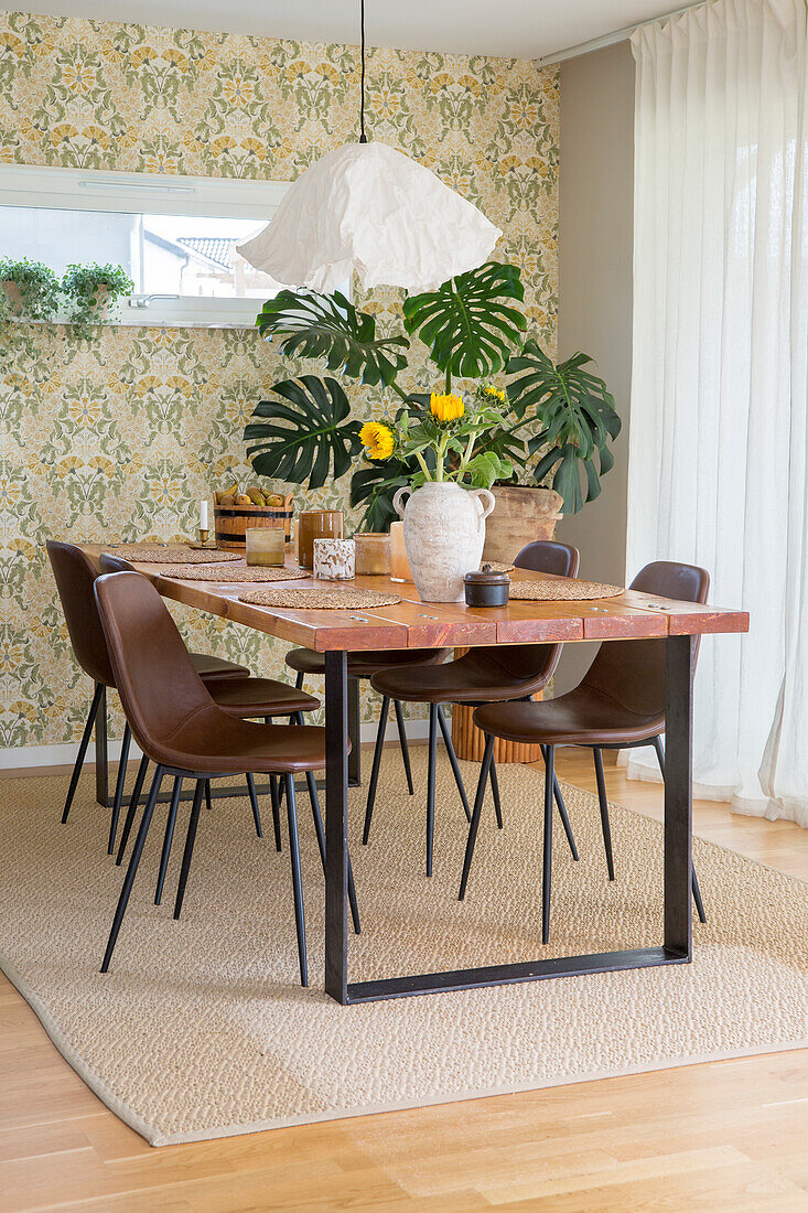 Dining area with wooden table, brown chairs and floral decorations