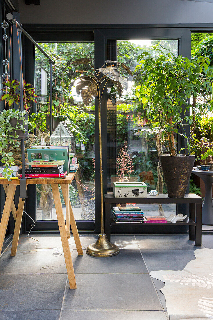 Conservatory with floor lamp, table and plants