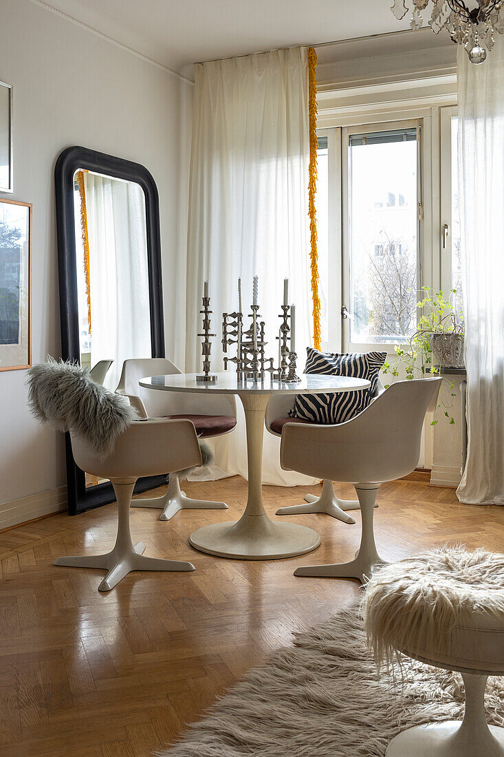 Dining area with white table, white chairs and mirror in an old-style room