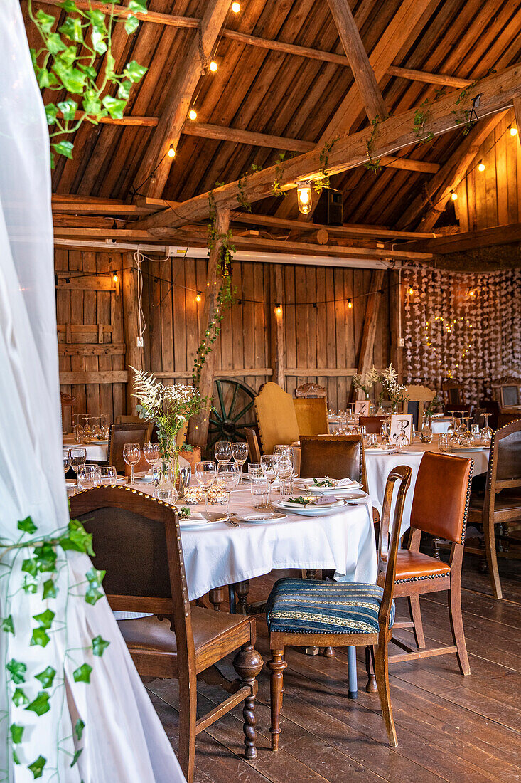 Rustic banquet hall with wooden ceiling and decorated tables