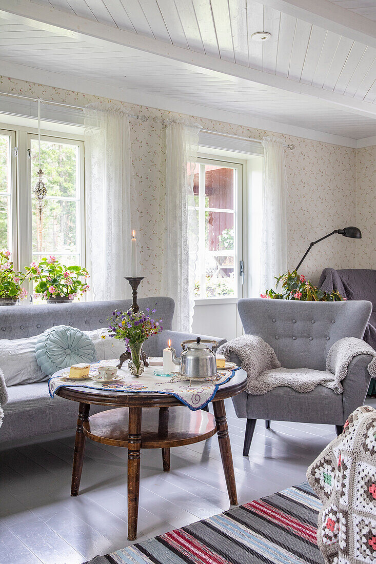 Country-style living room with grey sofa and rustic wooden table