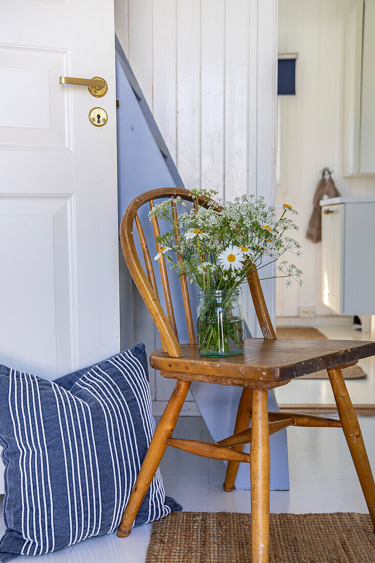Country-style hallway with wooden chair and fresh flowers