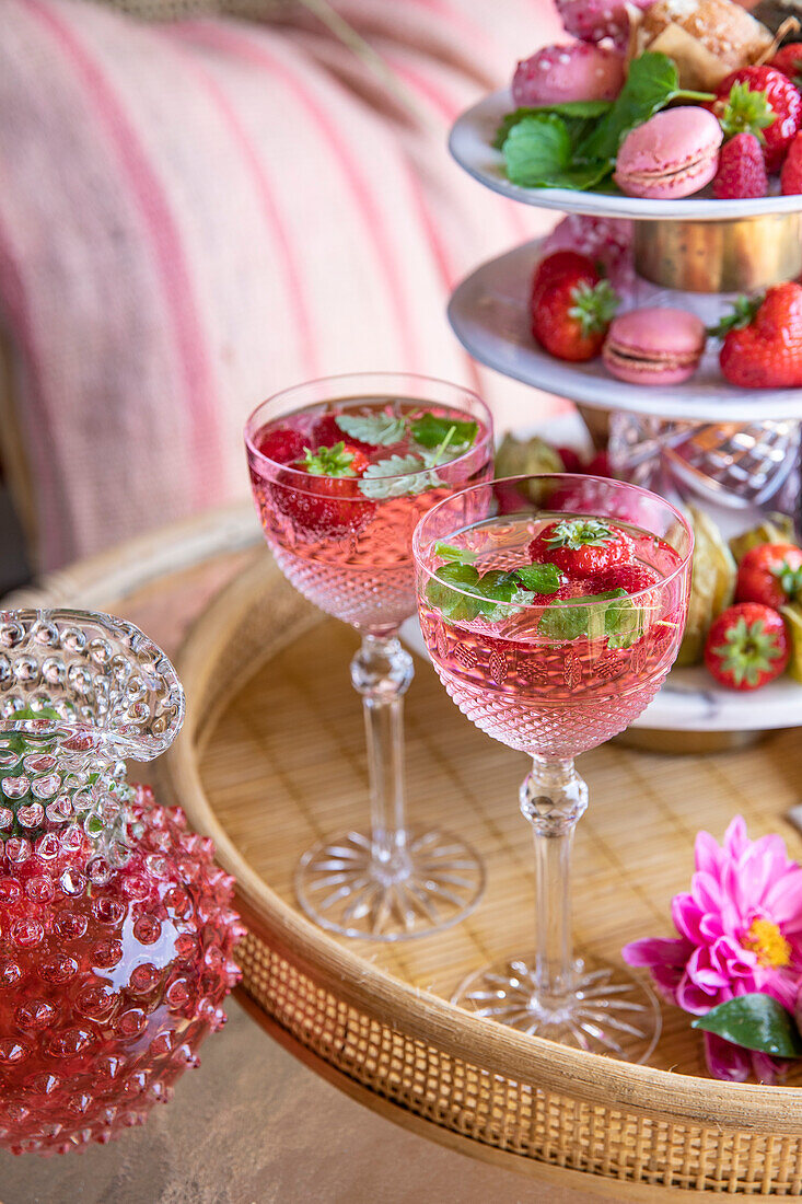 Getränke mit Erdbeeren und Minze auf einem Rattantablett