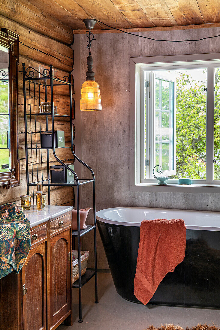 Freistehende Badewanne in rustikalem Badezimmer mit Holzelementen