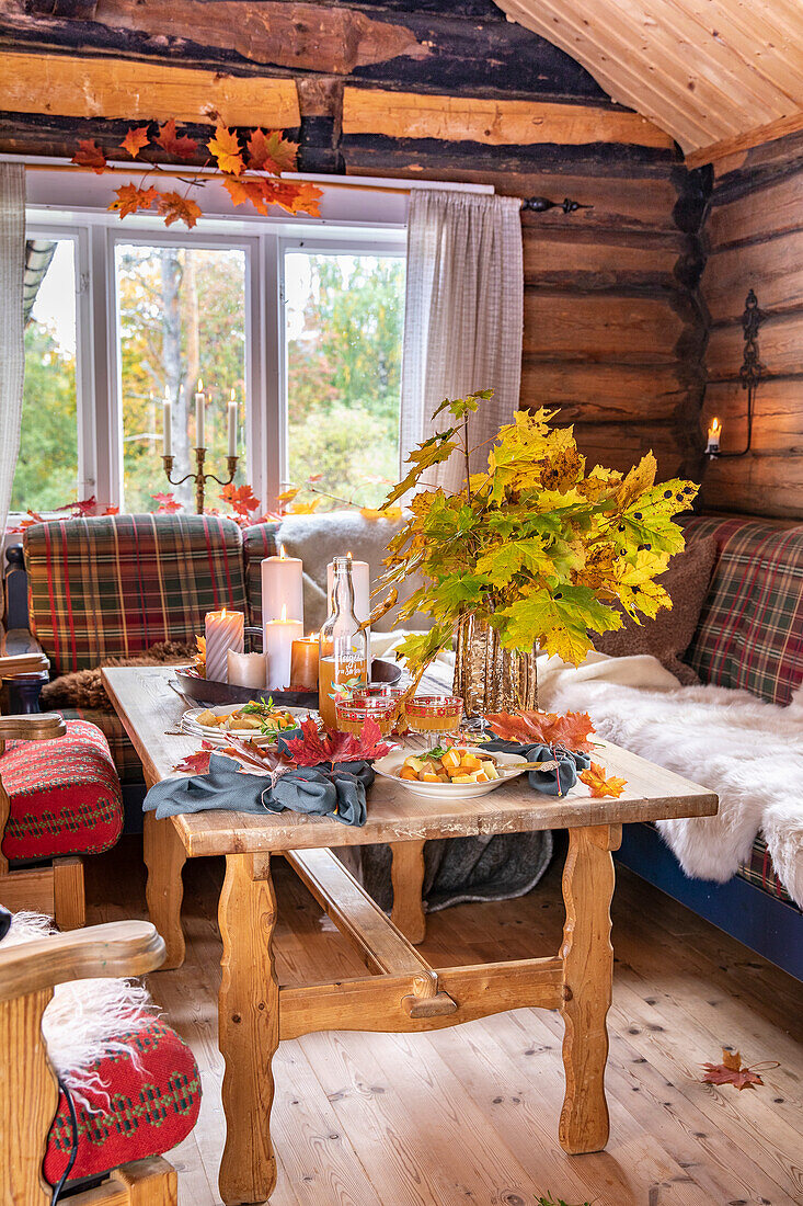 Table set with autumnal decorations in a rustic log cabin