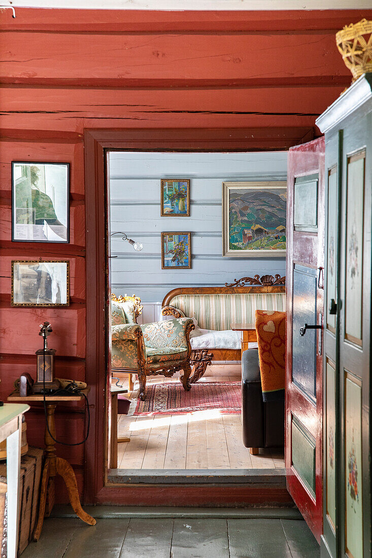 Blick in ein rustikales Wohnzimmer mit antiken Möbeln und Gemälden