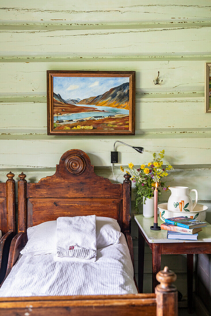 Holzbett mit weißer Bettwäsche und Nachttisch in rustikalem Schlafzimmer