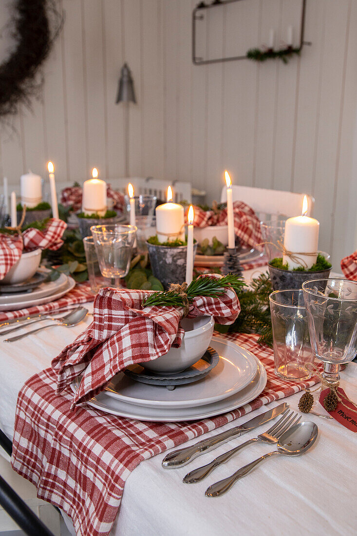 Festive dining table with candles and red and white chequered napkins