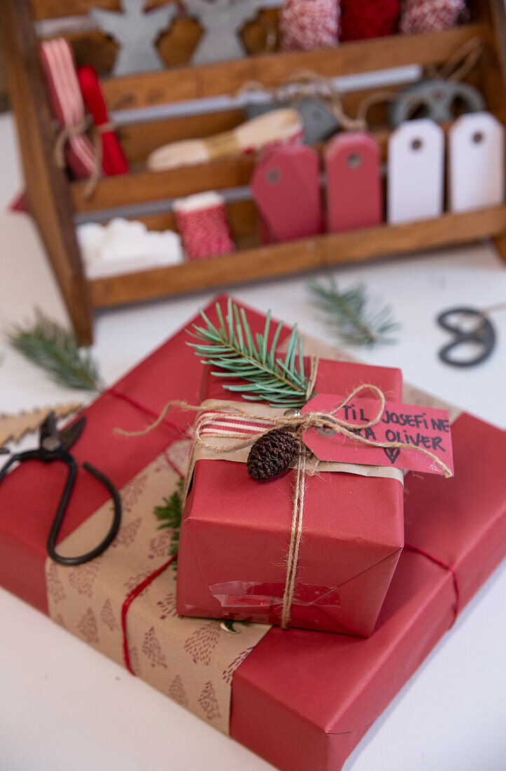 Christmas presents decorated with name labels, fir branches and cones