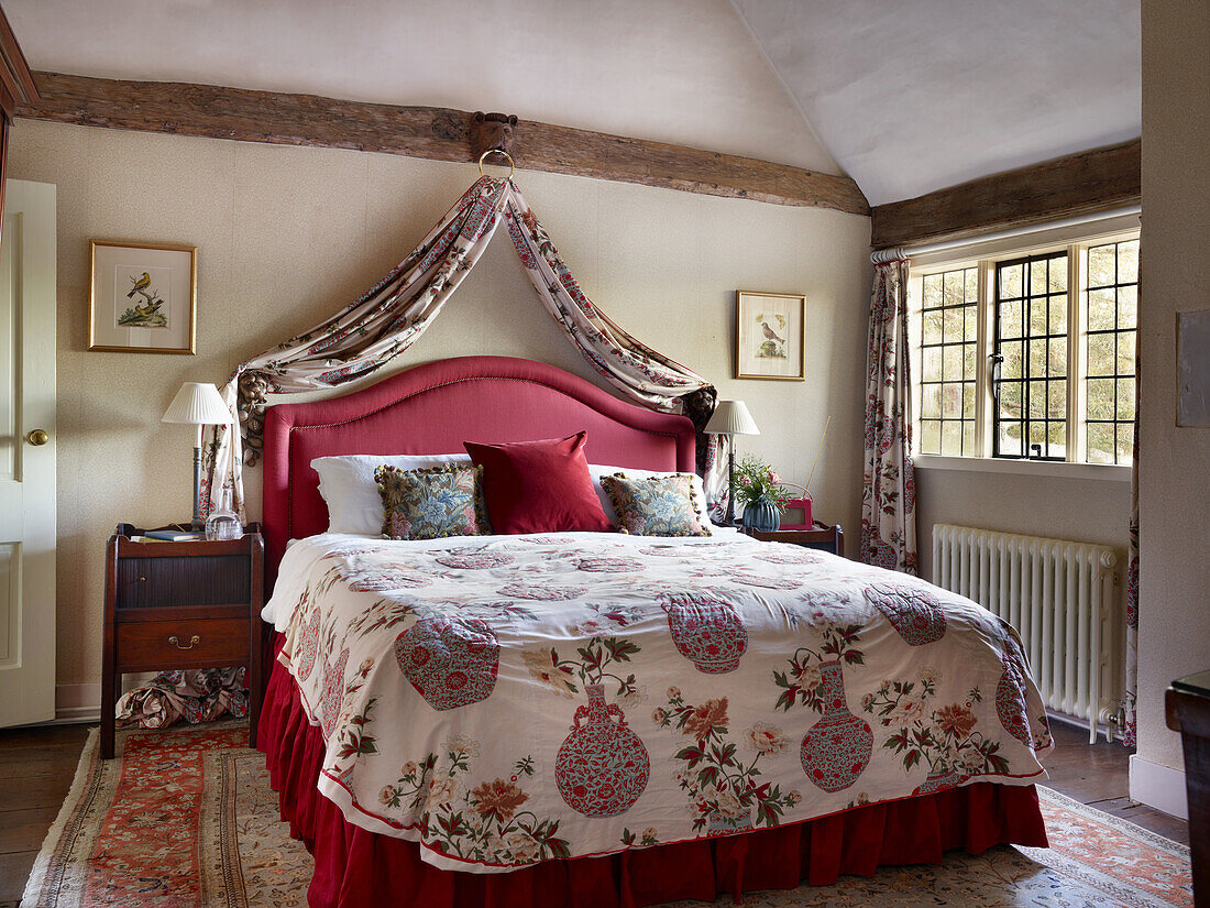 Country-style bedroom with four-poster bed and floral bed linen