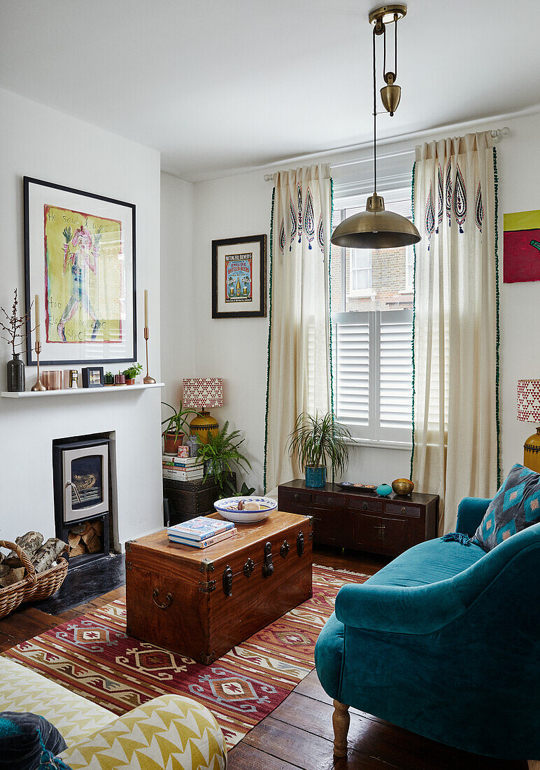 Wohnzimmer im Vintage-Stil mit blauem Sessel und Holztruhe als Couchtisch