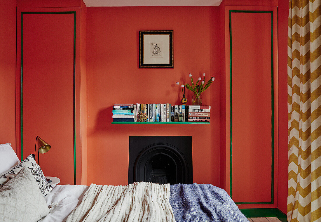 Schlafzimmer mit orangefarbenen Wänden und gestreiften Vorhängen