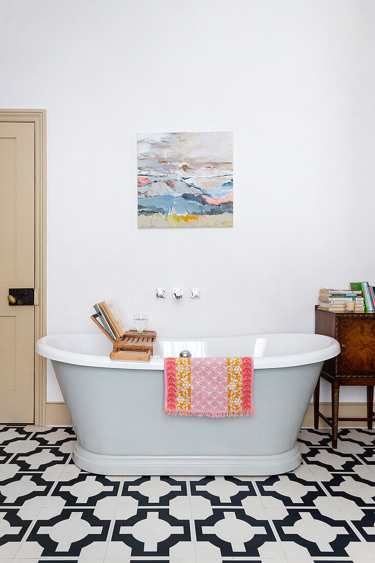 Freestanding bathtub on black and white patterned floor tiles