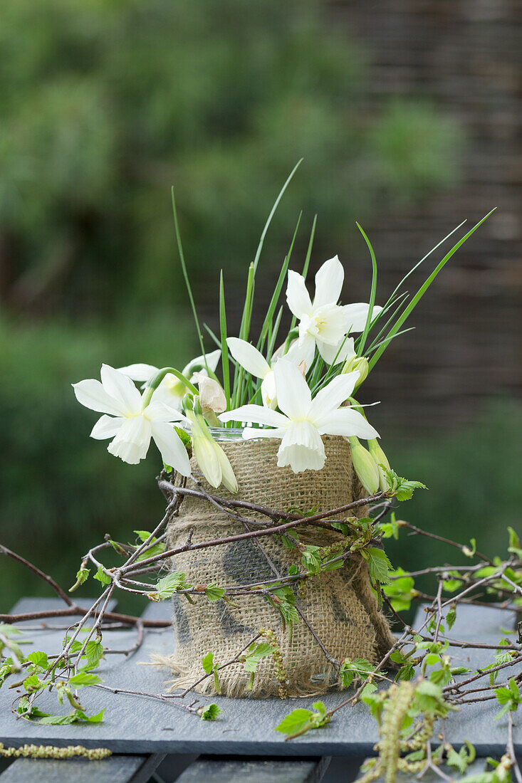 DIY vase made of jar and sackcloth with white daffodils