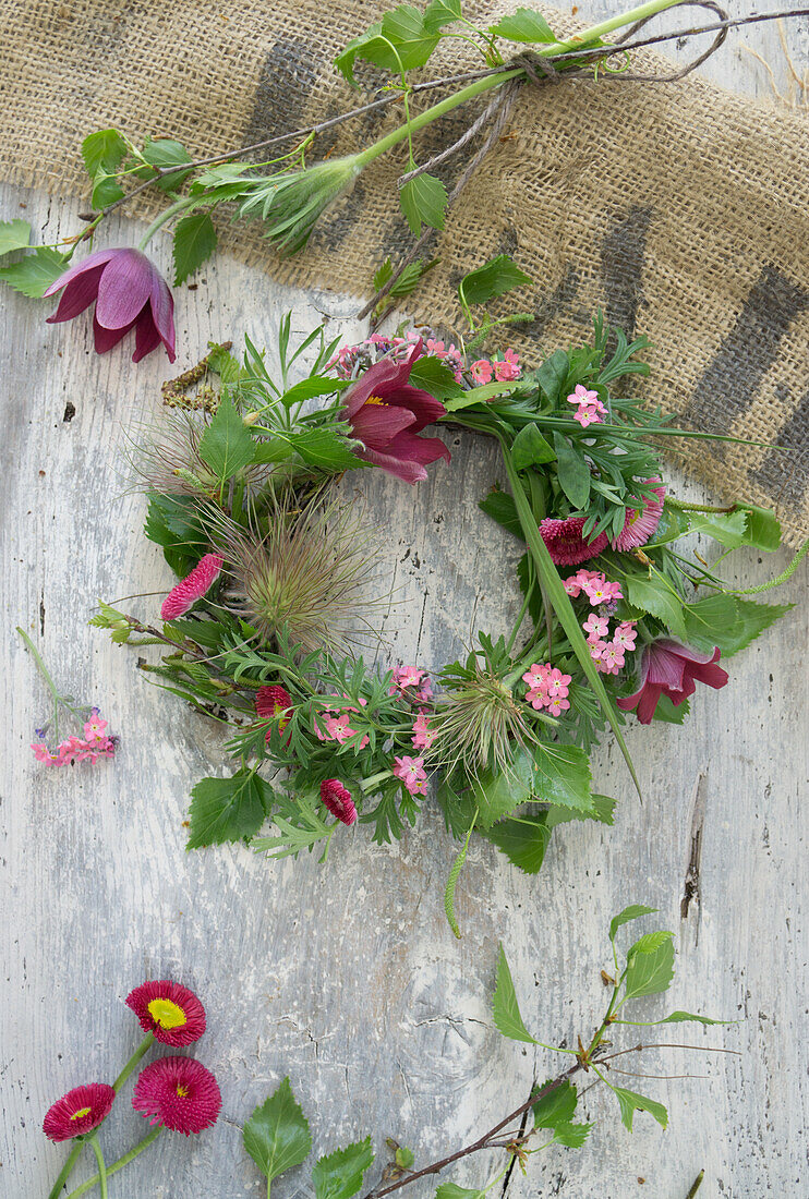 Wreath of pasque flower (Pulsatilla), forget-me-not, daisy (Bellis) and birch twigs