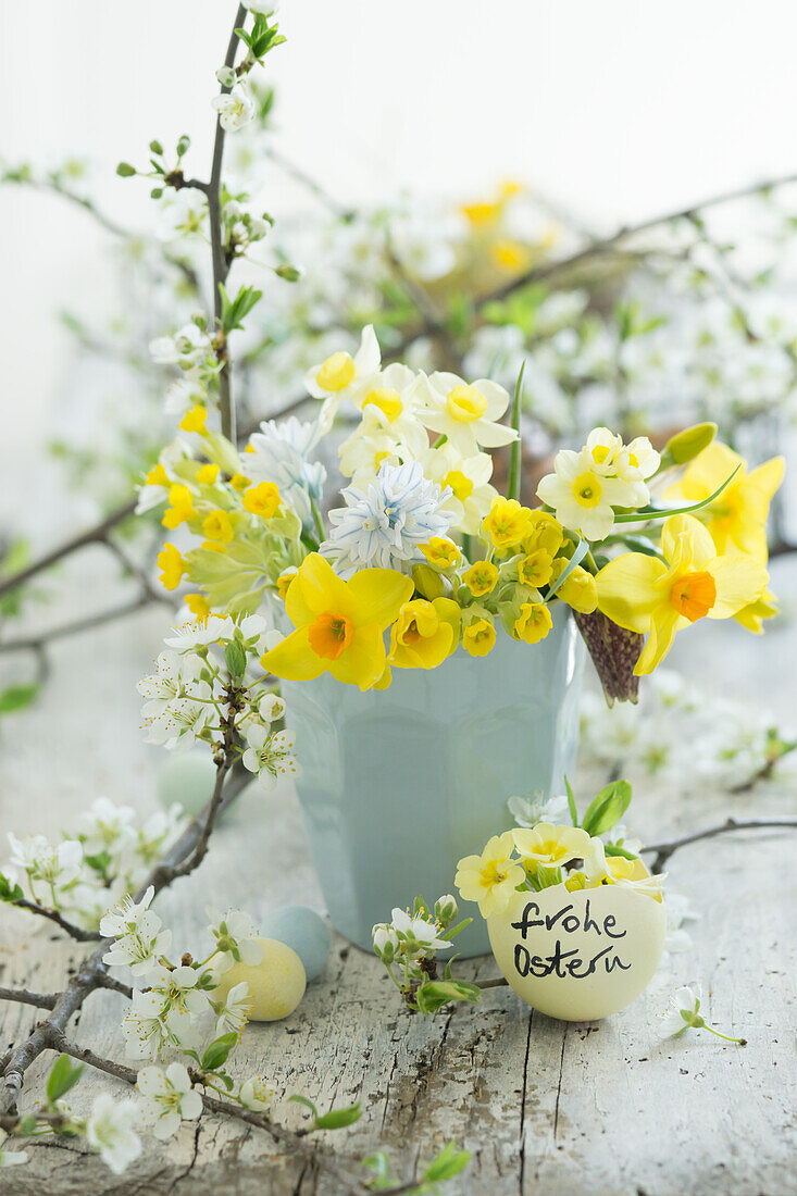 Arrangement with bouquet of spring flowers and fruit blossoms, eggshell with Easter greeting