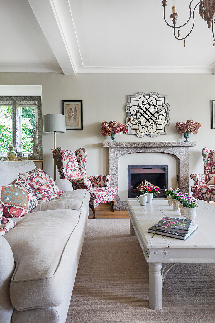 Living room with white furniture, patterned armchairs and fireplace