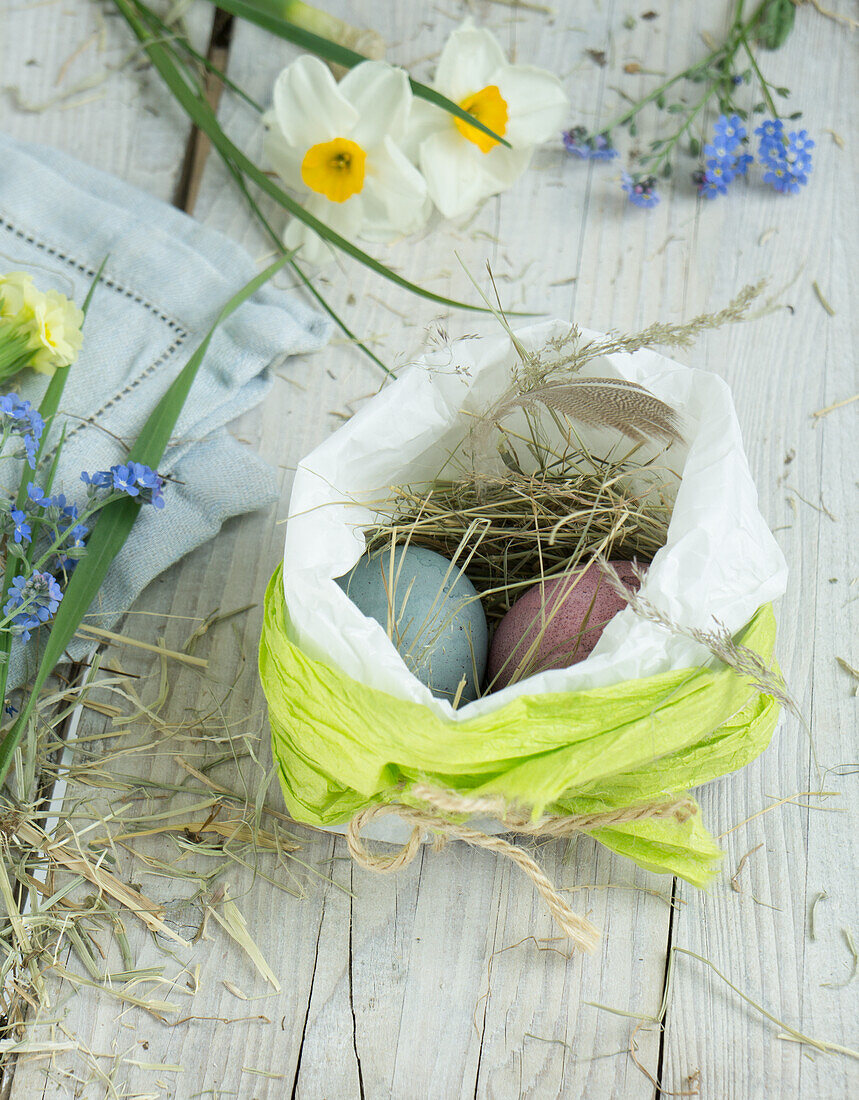 Easter nest in paper bag with Easter eggs and hay