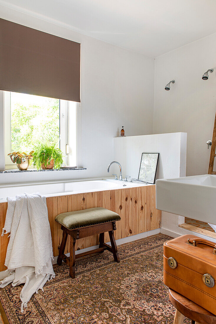 Bathtub with wooden paneling and vintage carpet on the floor