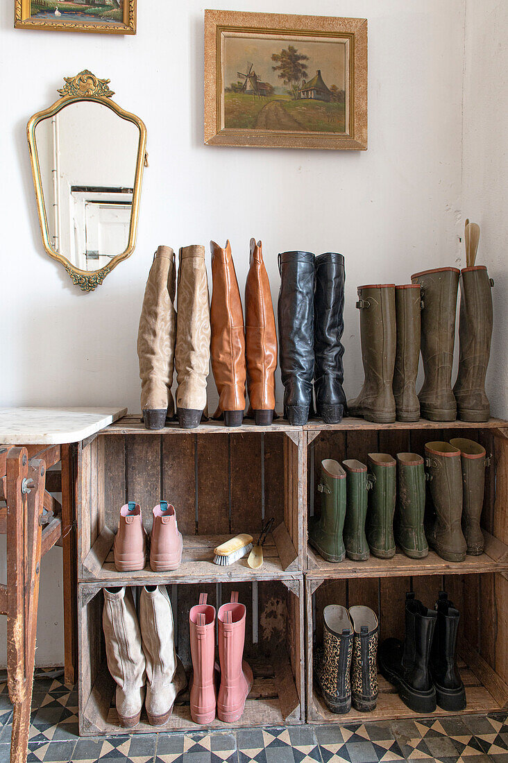 Wooden box shoe rack in the hallway with various boots