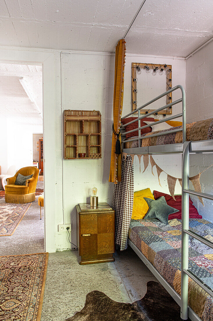 Metal bunk beds with patchwork quilts in a rustic children's room