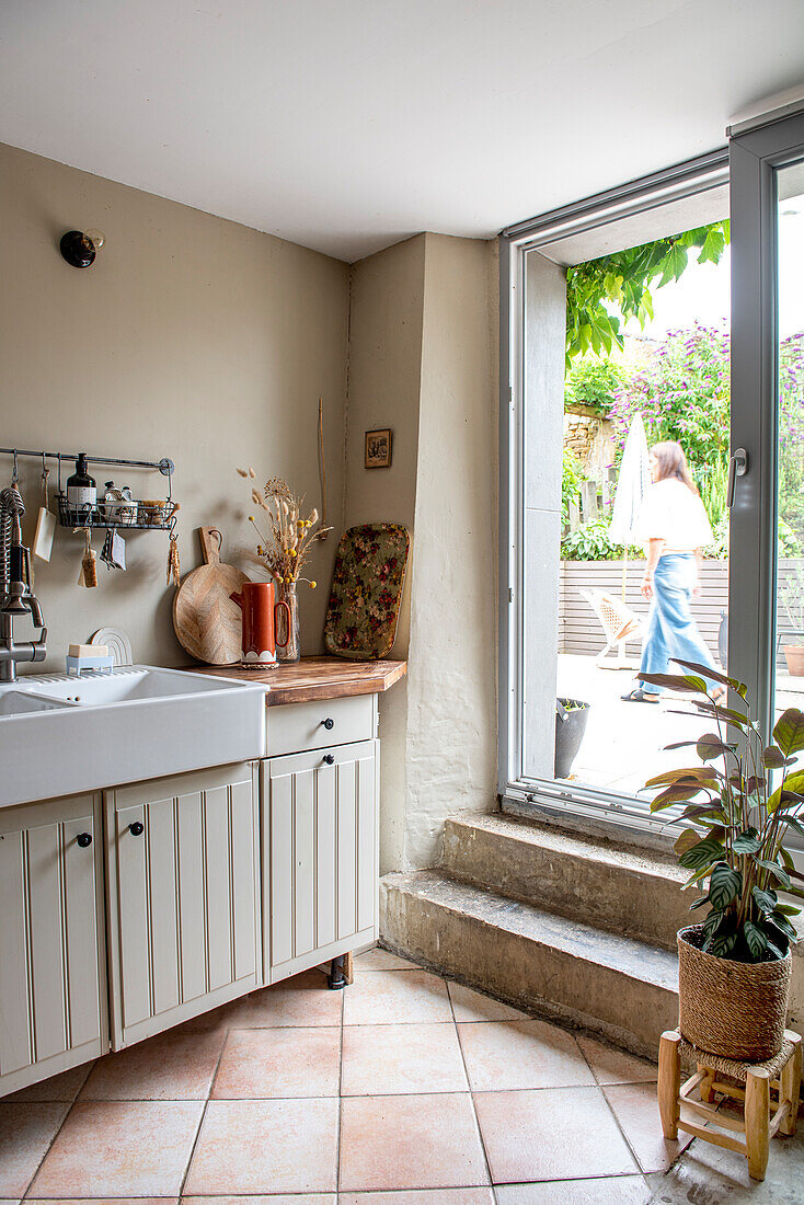 Helles Küchendesign mit Terrakottafliesen und Blick auf Terrasse