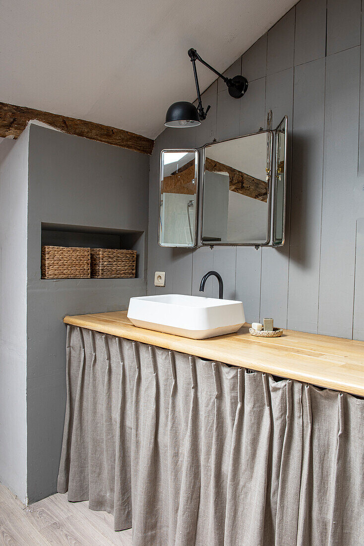 Bathroom with wooden vanity and rustic fabric curtain