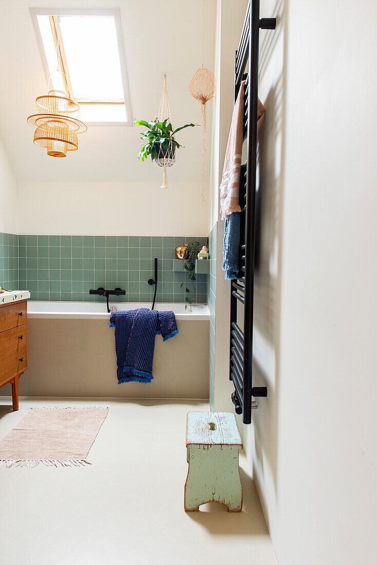 Bathroom with green wall tiles and black towel holder