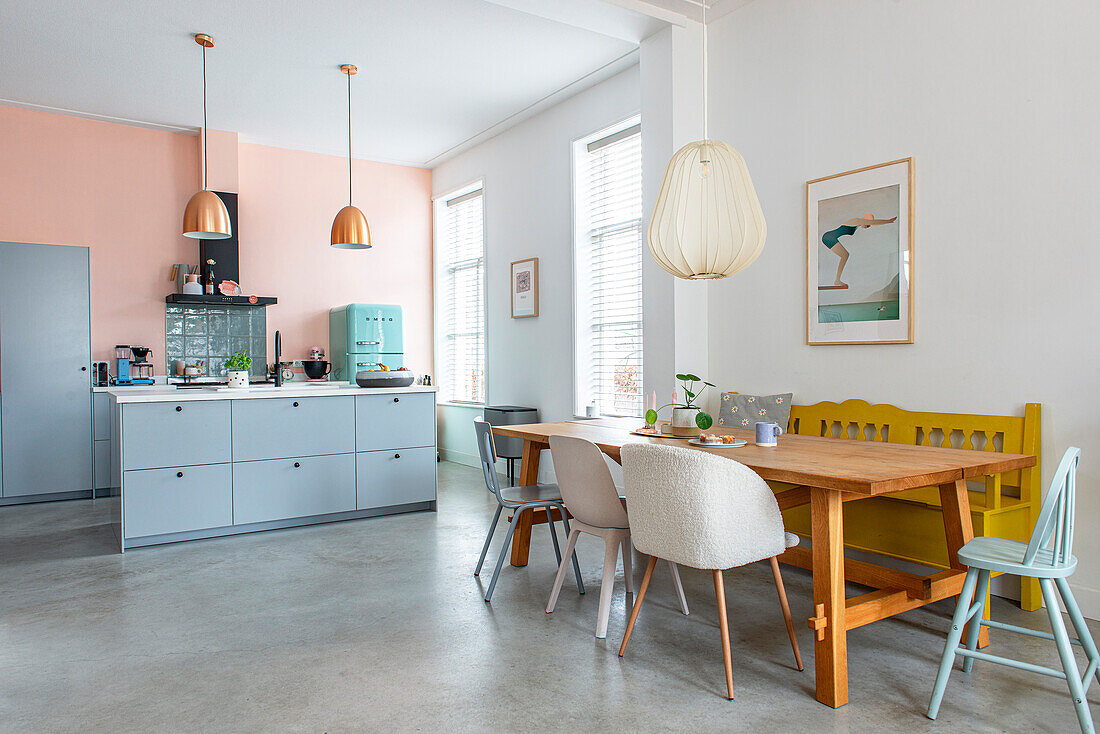 Küche mit Holzesstisch, Retro-Einrichtung und pastellfarbenen Wänden