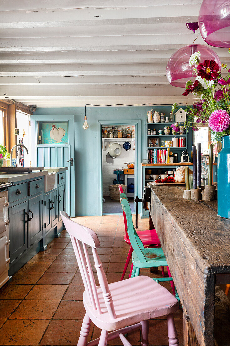Colourful country-style kitchen with wooden furniture and terracotta floor