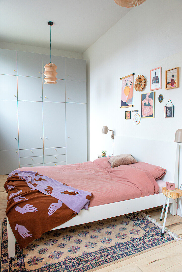 Schlafzimmer mit großem Einbauschrank, Wanddekor und orientalischem Teppich