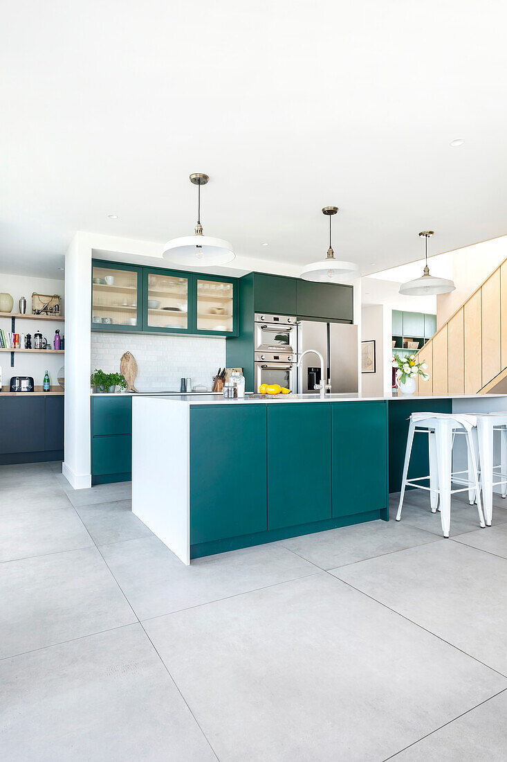 Modern kitchen with green-blue kitchen island and white bar stools