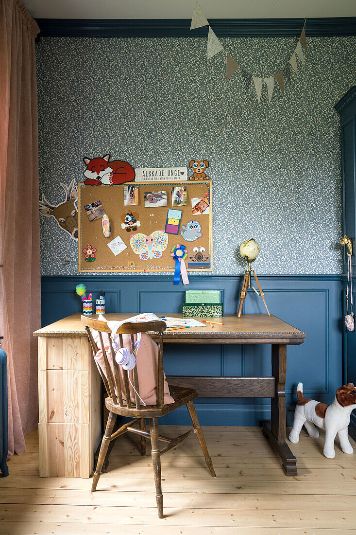 Schreibtischecke im Kinderzimmer mit Pinnwand und Holzstuhl