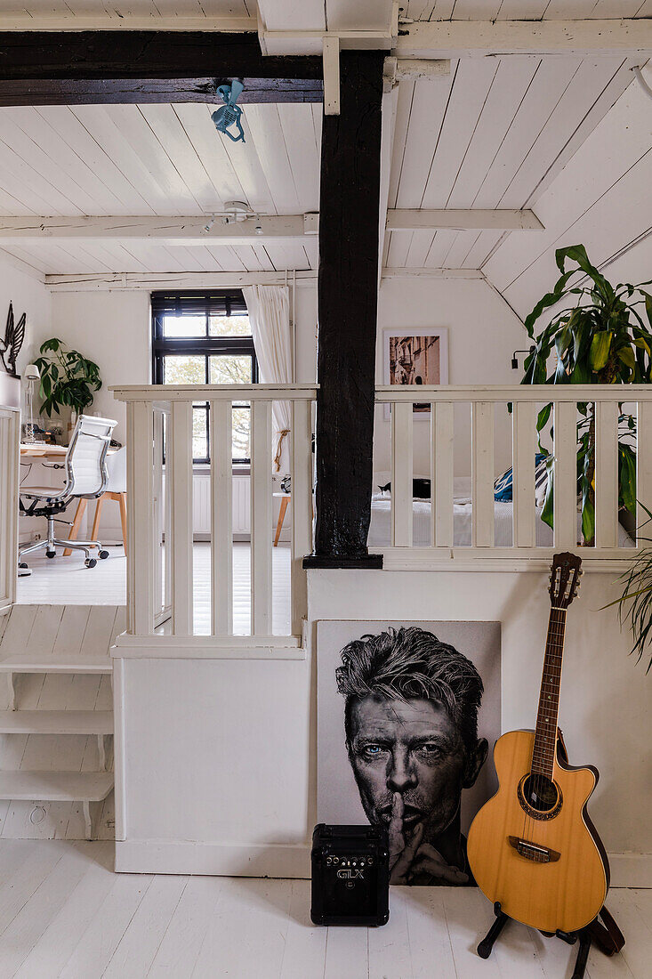 Small staircase leads to the home office, guitar and large portrait one level below