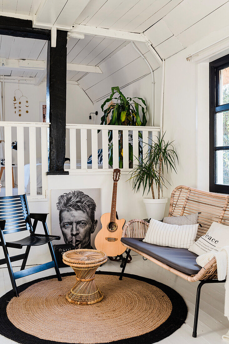 Living room on two levels with rattan bench, guitar and houseplants