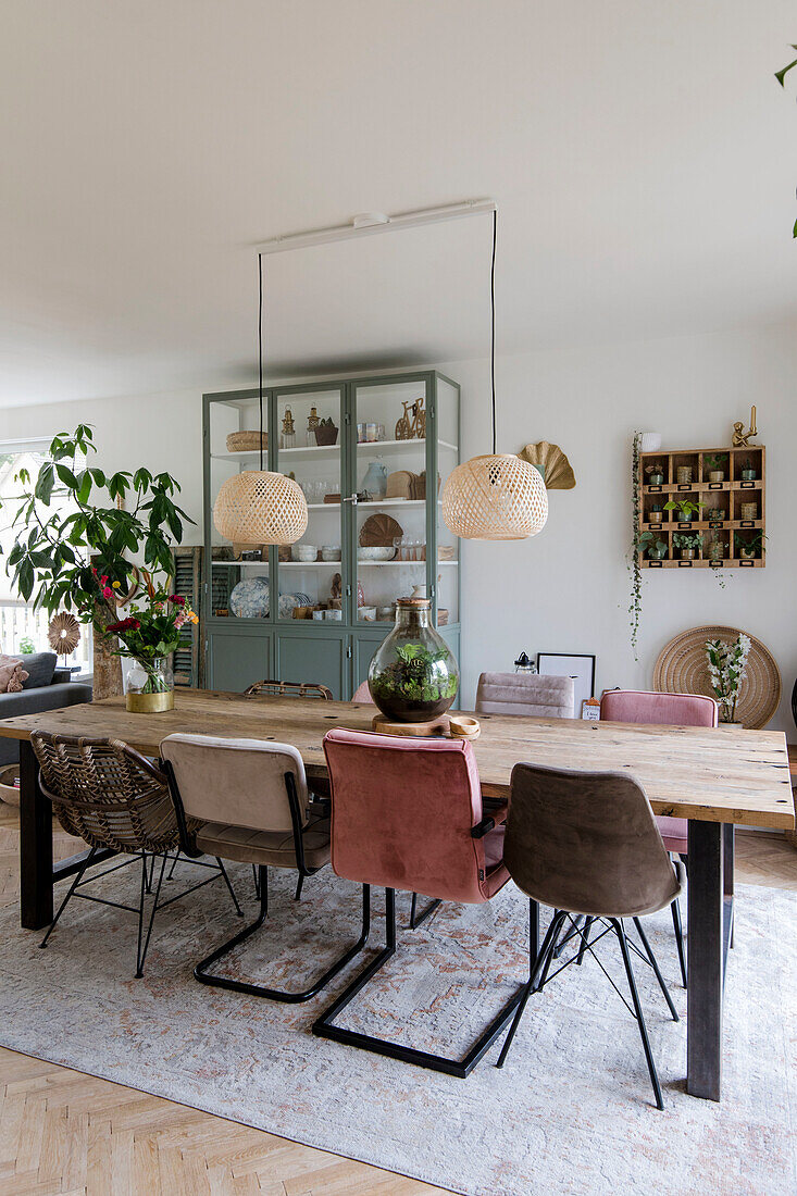 Dining table with chairs in different styles and rattan pendant lights